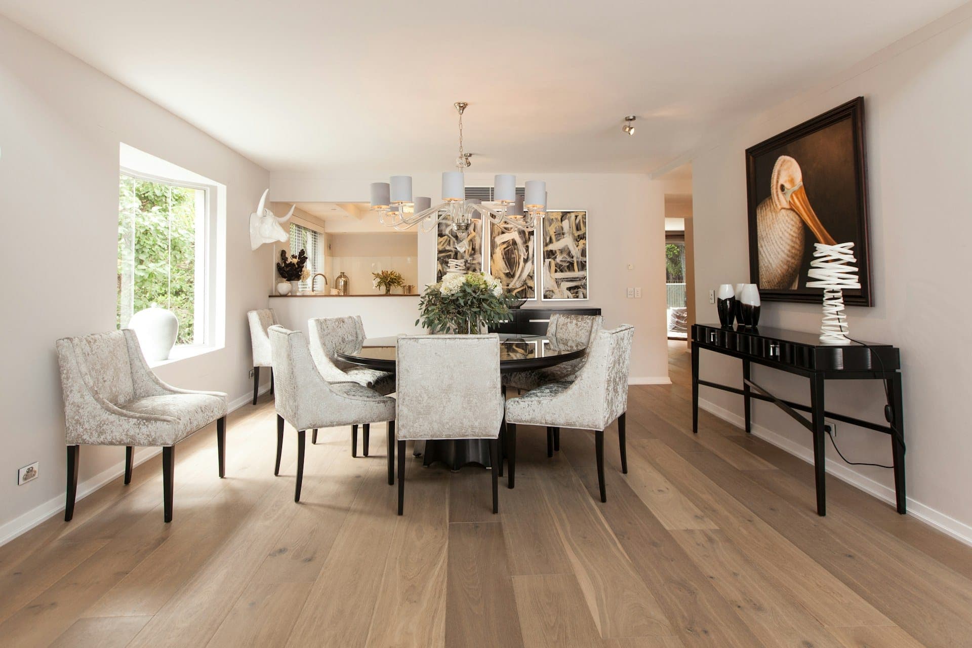 Dining room with pale wide plank flooring and large windows