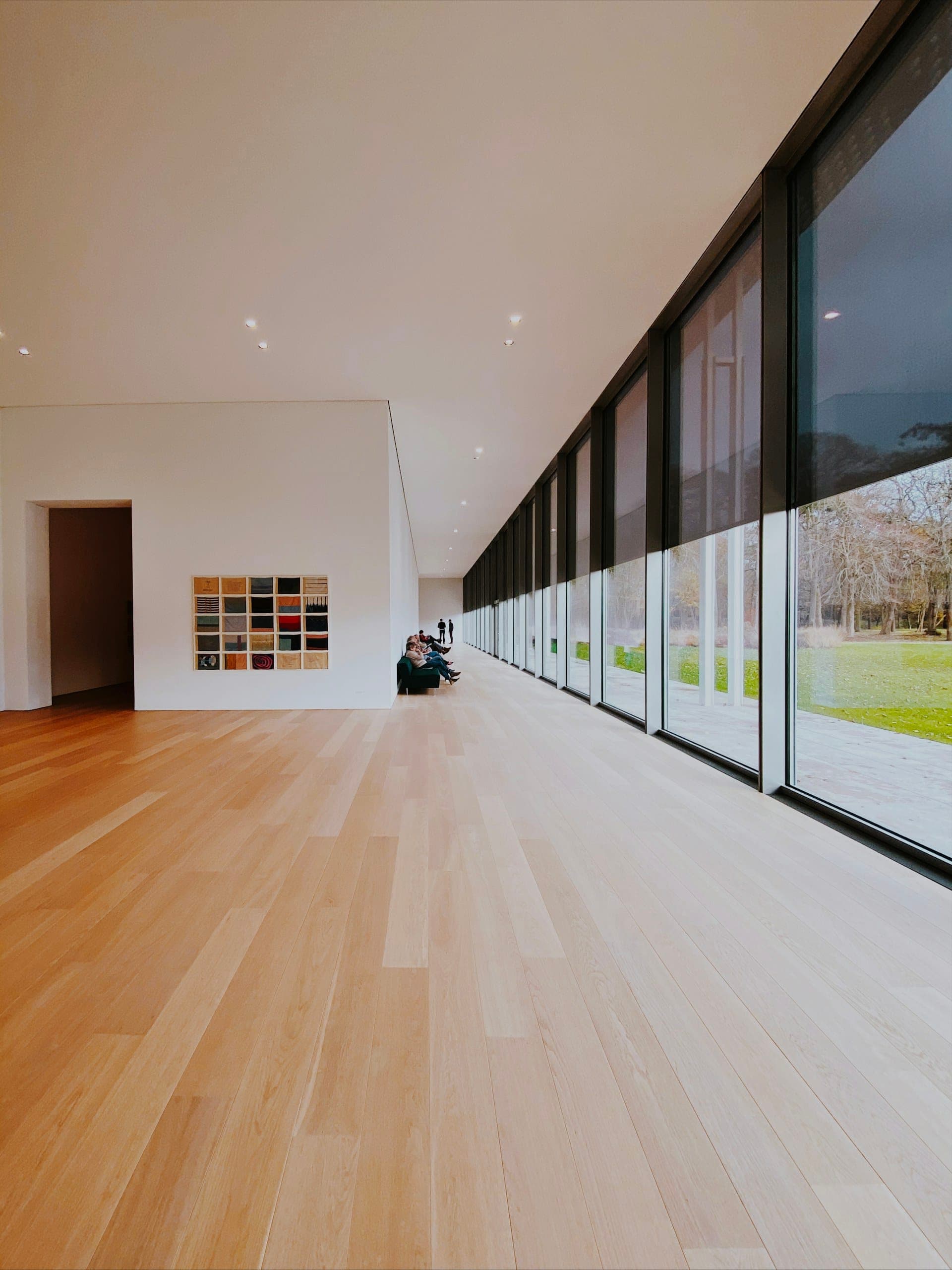 Long room with a wall of windows and plank flooring running the length of it