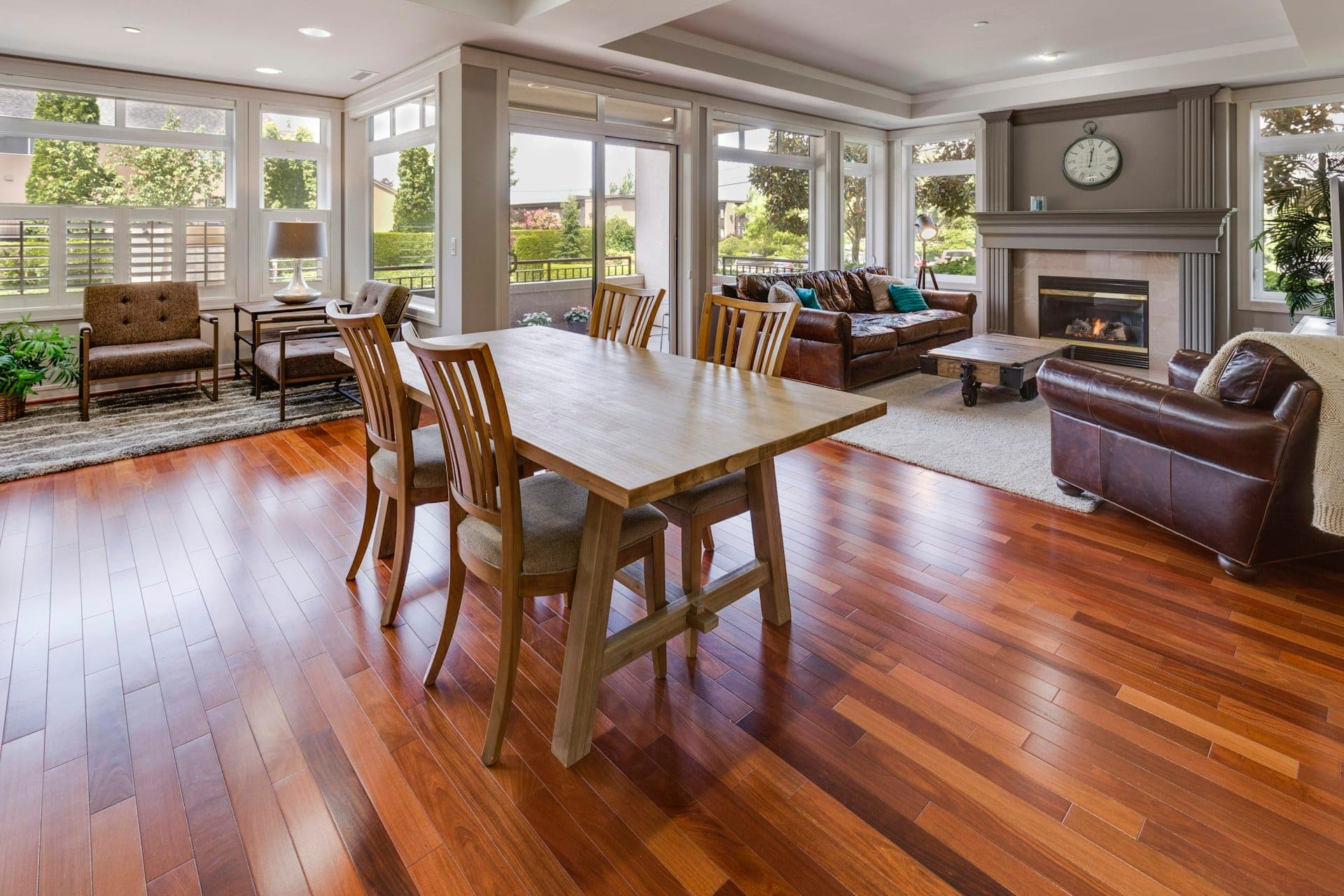 Open plan dining and living area with warm toned wood-look plank flooring